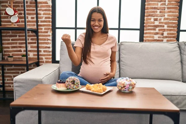 Joven Embarazada Comiendo Dulces Casa Gritando Orgullosa Celebrando Victoria Éxito —  Fotos de Stock