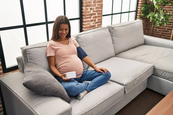 Mujer Embarazada Joven Usando Monitor Presión Arterial Sentado Sofá Sonriendo —  Fotos de Stock