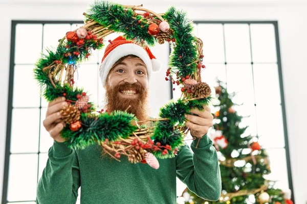 Νεαρός Κοκκινομάλλης Άντρας Χαμογελά Σίγουρος Κρατώντας Χριστουγεννιάτικη Διακόσμηση Στο Σπίτι — Φωτογραφία Αρχείου