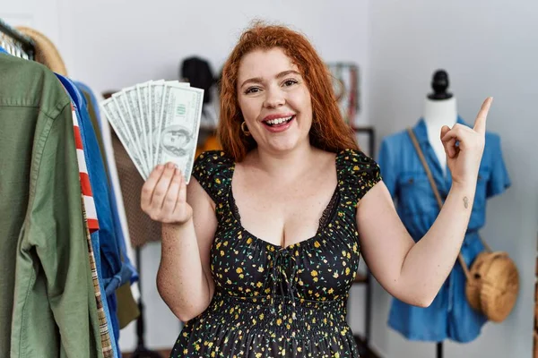 Jonge Roodharige Vrouw Houdt Boodschappentassen Dollars Glimlachend Vrolijk Wijzend Met — Stockfoto