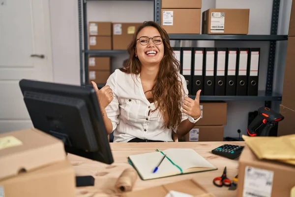 中小企業で働く若いヒスパニック系の女性は 手で積極的なジェスチャーを行う成功サイン 笑顔と幸せを親指アップ 陽気な表情と勝者のジェスチャー — ストック写真