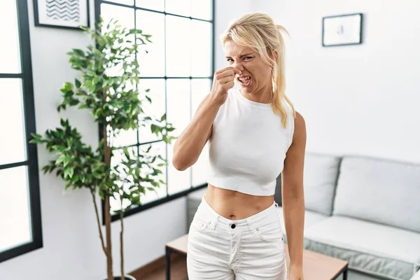 Young Caucasian Woman Standing Living Room Smelling Something Stinky Disgusting — Stok fotoğraf