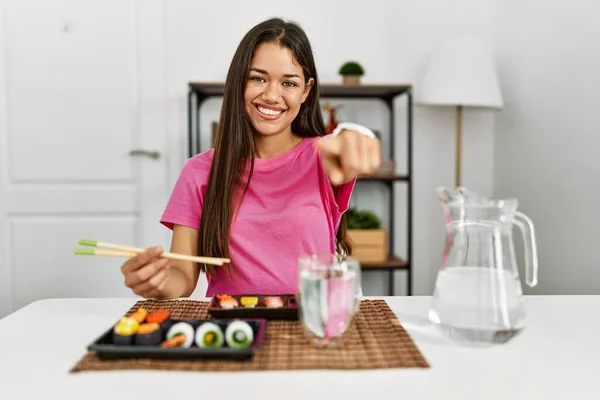 Joven Morena Comiendo Sushi Usando Palillos Apuntando Cámara Con Los —  Fotos de Stock