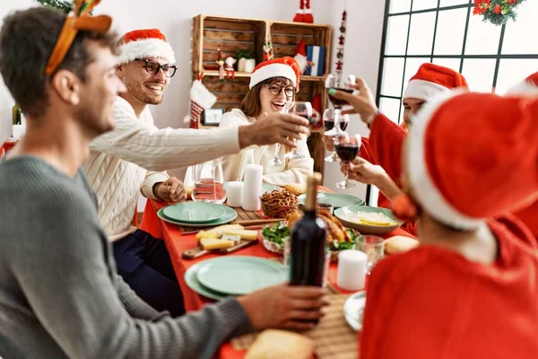 家でワインと一緒にクリスマスの乾杯を祝う幸せ笑顔の若者のグループ — ストック写真