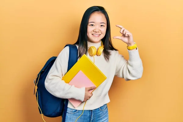 Young Chinese Girl Holding Student Backpack Books Smiling Confident Gesturing — Fotografia de Stock