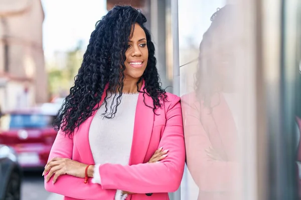 African american woman executive standing with arms crossed gesture at street