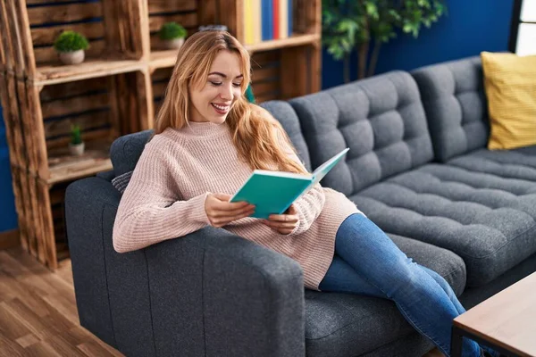 Νεαρή Γυναίκα Διαβάζει Βιβλίο Κάθεται Στον Καναπέ Στο Σπίτι — Φωτογραφία Αρχείου