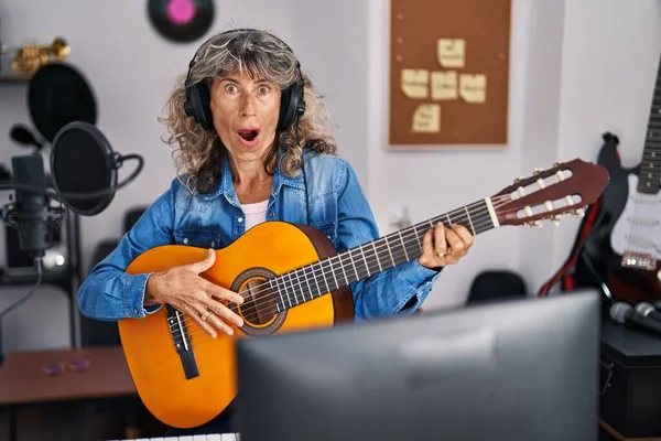 在音乐演播室弹奏古典吉他的中年妇女惊慌失措 张大嘴巴惊愕不已 — 图库照片