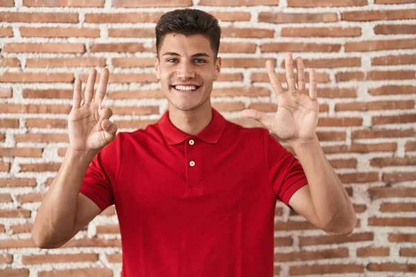 Young Hispanic Man Standing Bricks Wall Showing Pointing Fingers Number — Stockfoto