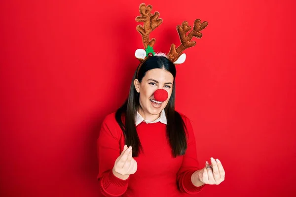 Mladá Hispánka Jelením Vánočním Klobouku Červeném Nose Dělá Gesto Peněz — Stock fotografie