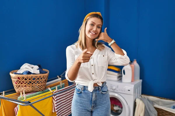 Young Blonde Woman Laundry Room Smiling Doing Talking Telephone Gesture — Stockfoto