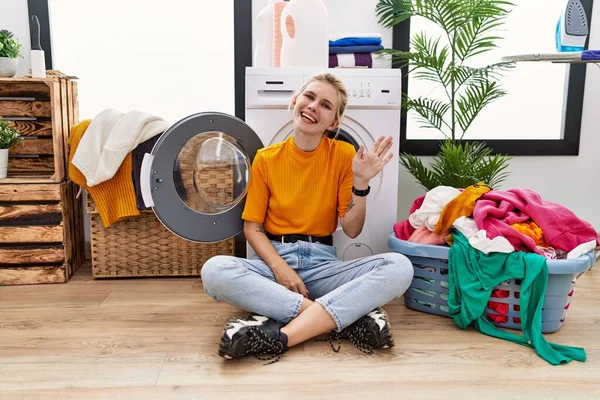 Young Blonde Woman Doing Laundry Sitting Washing Machine Waiving Saying — Stockfoto