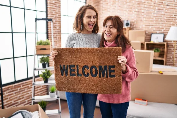 Mother Daughter Holding Welcome Doormat Winking Looking Camera Sexy Expression — ストック写真