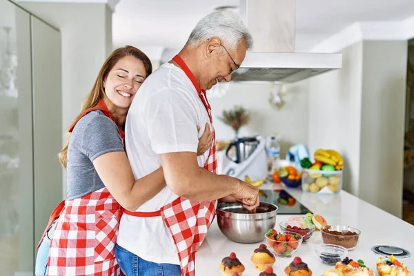 Casal Hispânico Meia Idade Sorrindo Feliz Abraçando Doces Cozinha Cozinha — Fotografia de Stock