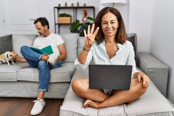Hispanic Middle Age Couple Home Woman Using Laptop Showing Pointing — Stok Foto