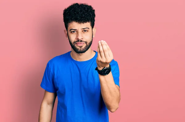 年轻的阿拉伯男子 留着胡子 穿着休闲的蓝色T恤 手指手画脚地做着意大利式的手势 — 图库照片