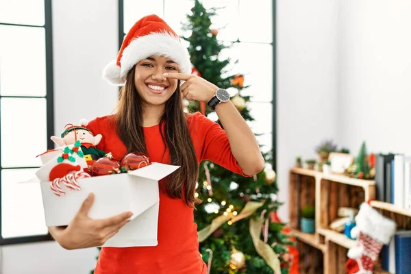 Mulher Morena Jovem Junto Árvore Natal Segurando Decoração Apontando Com — Fotografia de Stock