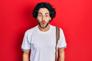 Yakışıklı, beyaz tişört giyen, ağzı açık, korkmuş ve şaşırmış bir İspanyol. 