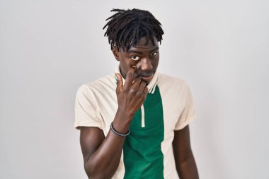 Afrikalı bir adam izole edilmiş arka planda dikiliyor. Göze işaret ediyor. Jestini izliyor. 