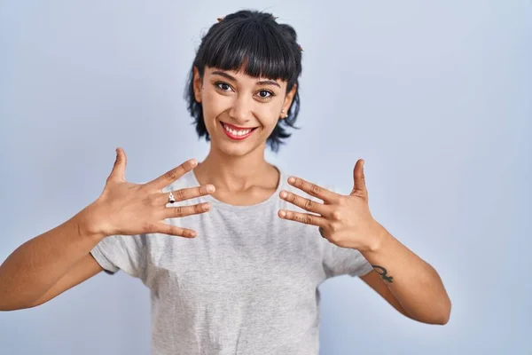 Mujer Hispana Joven Vistiendo Camiseta Casual Sobre Fondo Azul Mostrando —  Fotos de Stock