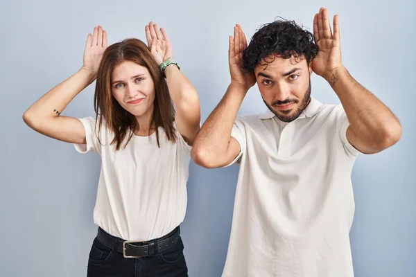 Young Couple Wearing Casual Clothes Standing Together Doing Bunny Ears — Stockfoto