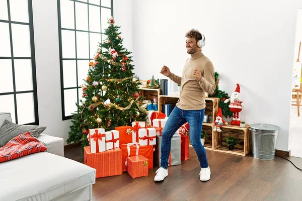 Joven Hispano Escuchando Música Bailando Pie Junto Árbol Navidad Casa —  Fotos de Stock