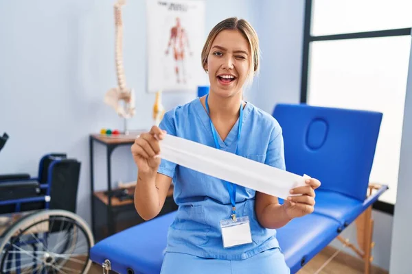 Young Blonde Woman Holding Therapy Strip Band Winking Looking Camera — Fotografia de Stock