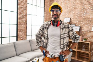 Young hispanic man worker smiling confident standing at home