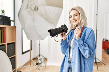Fotoğrafçılık stüdyosunda profesyonel fotoğrafçı olarak çalışan güzel sarışın kadın. Sdxc bellek kartı duruyor