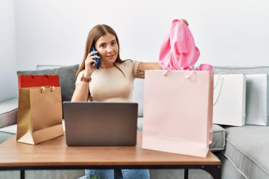 Genç İspanyol kadın akıllı telefondan evde sipariş veriyor.