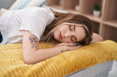 Young woman lying on sofa sleeping at home