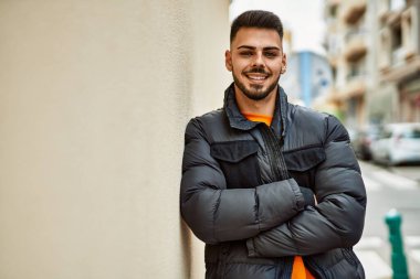 Yakışıklı, sakallı, neşeli ve kendine güvenen, kışlık palto giyen bir İspanyol.