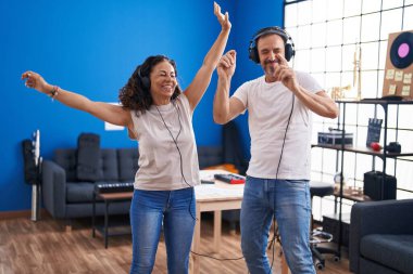 Man and woman musicians singing song at music studio