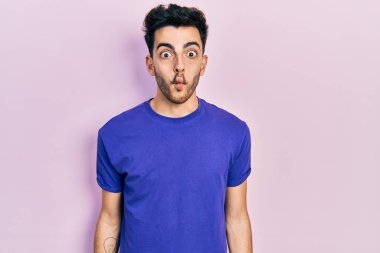 Gündelik tişört giyen genç İspanyol adam dudaklarıyla balık suratı yapıyor, çılgınca ve komik bir jest. Komik ifade. 