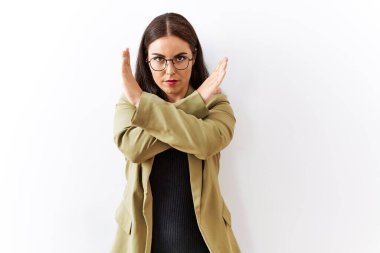 Genç esmer kadın, izole edilmiş arka planda duruyor. Reddedilme ifadesi, kollarını kavuşturma, olumsuz işaret, kızgın yüz ifadesi. 