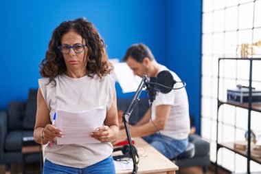 Middle age hispanic woman singing at music studio skeptic and nervous, frowning upset because of problem. negative person. 