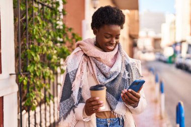 Sokakta kahve içen Afro-Amerikan kadın.