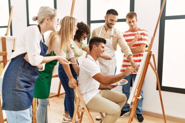 Mutlu gülümseyen ve ortak arayan bir grup insan sanat stüdyosunda..