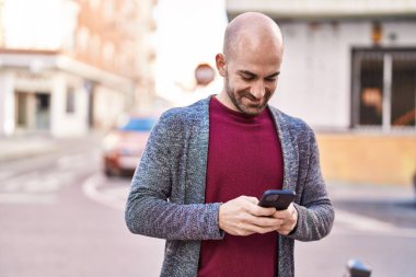 Sokakta akıllı telefon kullanan kendine güvenen genç adam.