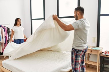 Genç Latin çift gülümsüyor, mutlu mesut evlerinde yatıyorlar..