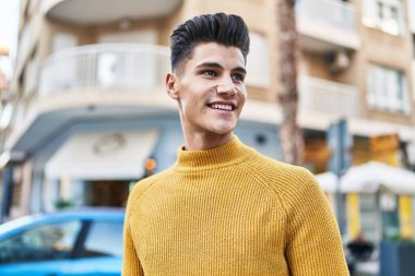 Sokakta kendinden emin gülümseyen İspanyol genç adam.