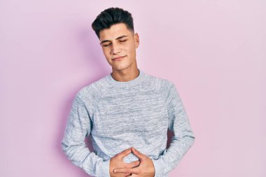 hazımsızlık, acı verici bir hastalık ve midesi kötü hissettiği için günlük giysiler giyen genç İspanyol bir adam. Ağrı kavramı. 