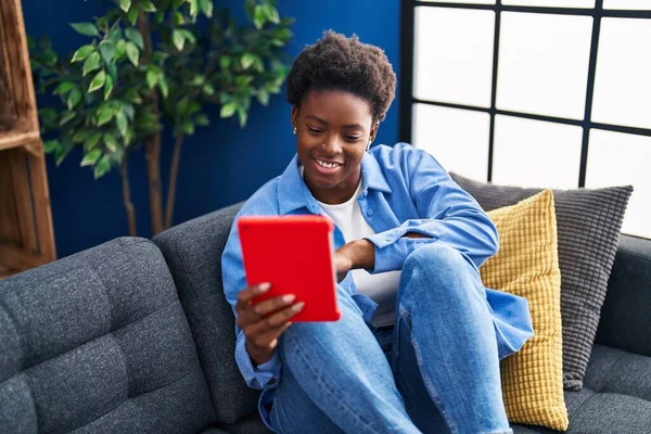 African American Γυναίκα Χρησιμοποιώντας Touchpad Κάθεται Στον Καναπέ Στο Σπίτι — Φωτογραφία Αρχείου