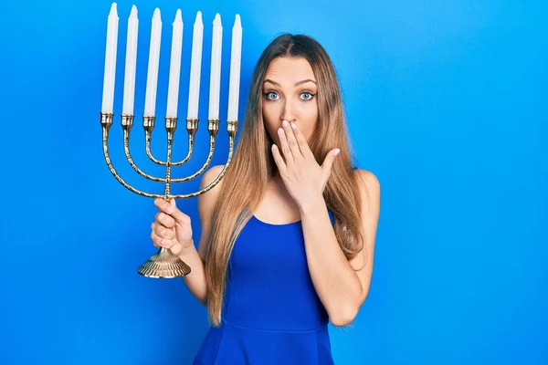 Young Blonde Girl Holding Menorah Hanukkah Jewish Candle Covering Mouth — Stock Photo, Image