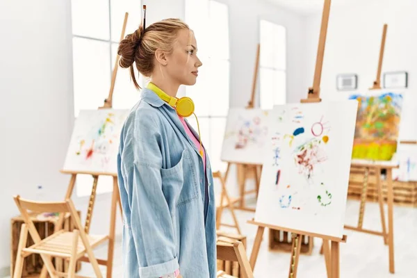 Young caucasian girl at art studio looking to side, relax profile pose with natural face and confident smile.