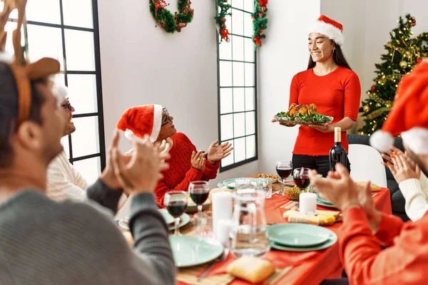 人々のグループを会議拍手とテーブルの上に座っている 女性立っていると開催ロースト七面鳥お祝いクリスマスで自宅 — ストック写真