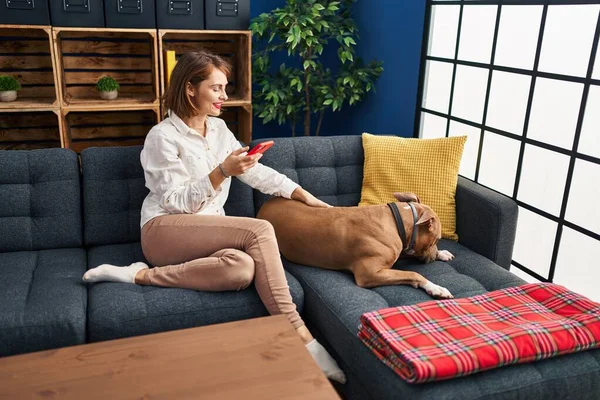 Young Caucasian Woman Using Smartphone Sitting Sofa Dog Home — Fotografia de Stock