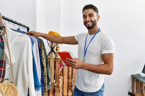 Joven Hombre Árabe Comerciante Usando Touchpad Pie Junto Perchero Ropa — Foto de Stock