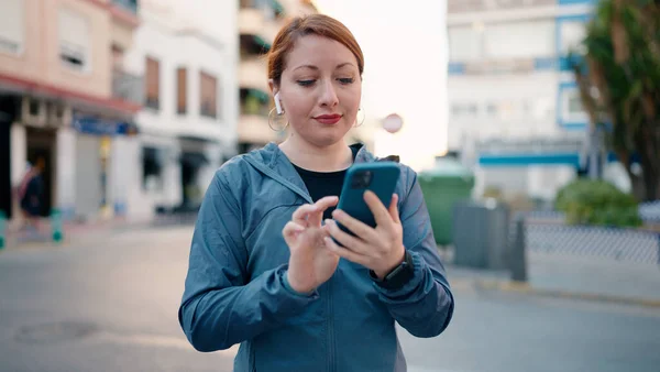 Young Redhead Woman Wearing Sportswear Listening Music Using Smartphone Street — Stockfoto