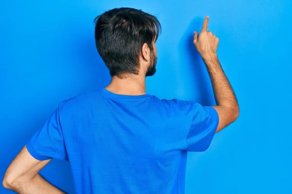 Junger Hispanischer Mann Lässiger Kleidung Posiert Rückwärts Und Zeigt Mit — Stockfoto